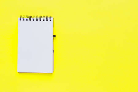 Clean spiral note book for notes on yellow background. Minimal business flat lay mock up