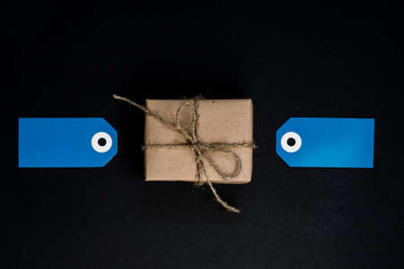 Handcrafted gift box wrapped in Craft paper with blue paper card tags for decoration.