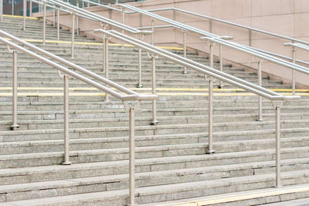 view to outdoor steps with metal railing in center of leading to entrance into modern building