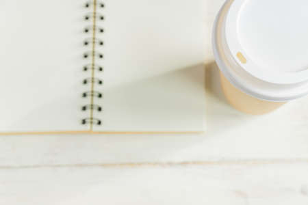 craft paper coffee cup and notebook diary with copy space on wooden table
