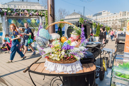 Moscow, Russia - April 25, 2019: Easter Holiday festival in Moscow. Wickered basket with colorful ester eggs, easter cake or kulich and beautiful spring flowers.のeditorial素材