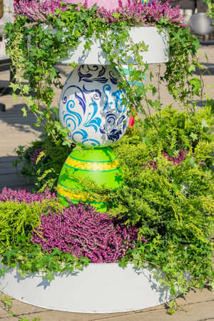 Beautiful flowerbed with colorful wooden eggs for easter decoration.の写真素材