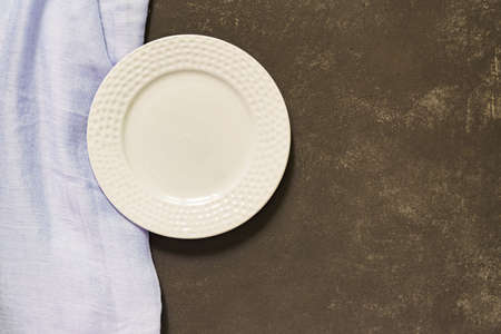 Top view of empty served plate, blue textile on black concrete background. Copy space.の写真素材