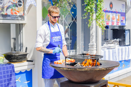 MOSCOW, RUSSIA - MAY 30, 2019: Fish Week festival, The chef prepares seafood on fire.のeditorial素材