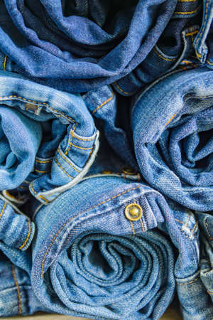 roll blue denim jeans arranged in stack, background texture. Beauty and fashion clothing conceptの写真素材
