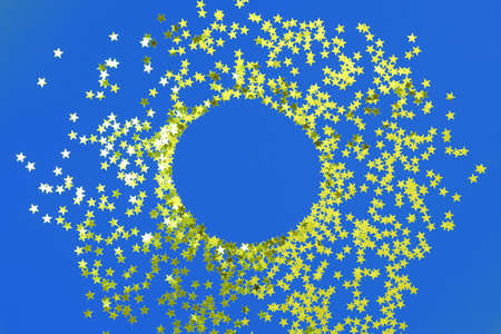 blue backdrop with glitter and gold stars confetti with copy space. Festive holiday bright...