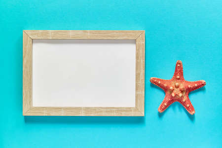 top view of photoframe with seashells and starfish on blue background. Summer vacation concept. Sea flat layの写真素材