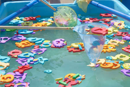 close up of floating colorful marine animal figures in the pool for catching a net. children's...