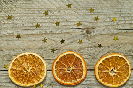 Dried orange slices and gold confetti in shap of star. Top view with copy space