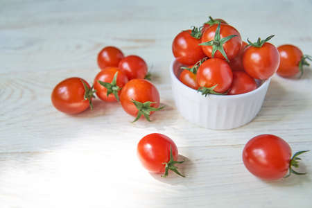 Fresh cherry tomatoes on white wooden table. Organic vegetables, healthy and dieting food, soft...