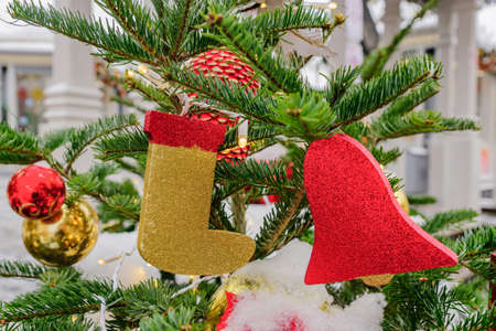 Close up of christmas tree decorated with balls, candy cane, bells and garlands. Festive street arrangementの写真素材