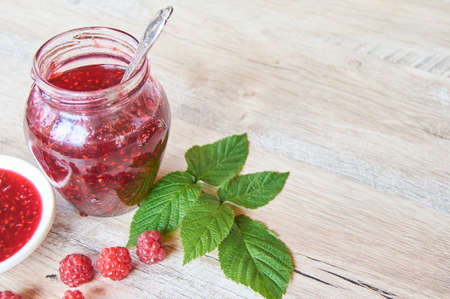 A Jar Of Raspberry Jam On Wooden Table. Copy space for your text