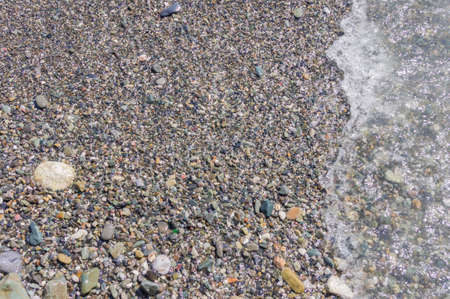pebble coastline. Seashore with transparent water and small stonesの写真素材