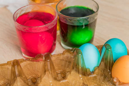 Glass with orange, red and green paint for Easter eggs. Easter Egg decorating.の写真素材