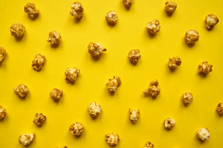 caramel poprocn pattern on yellow background. Top view, monochrome conceptの写真素材