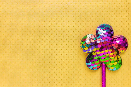 flower made of sequins on sparkling golden background. Minimal flat lay, copy spaceの写真素材