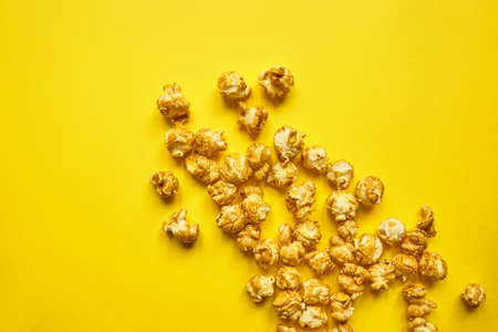 Popcorn with caramel on bright yellow backgroundの写真素材