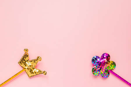 Golden crown and pink flower made of round sequins on pink background. Fashion party accessories with copy space. Festive flat lay. Minimal style.の写真素材