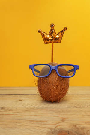 Funny coconut in glasses with sequin crown toned pink. Summer and travel conceptの写真素材