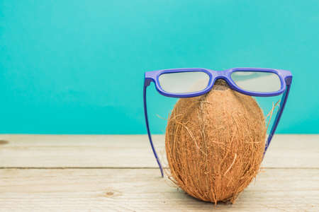 A cocnut wearing 3D glasses on blue background. Summer and travel conceptの写真素材