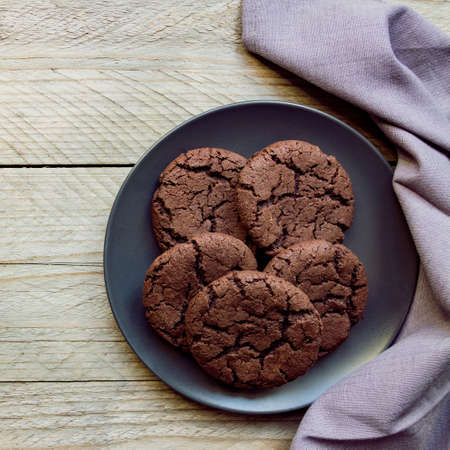 Top view, chocolate chip cookies on a black plate. wooden background. From above.