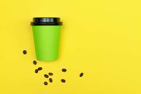 Close up of coffee to go cup on bright yellow background. Eco concept. Place for text.