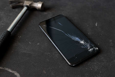 Cracked mobile smartphone smashed by a hummer.の写真素材