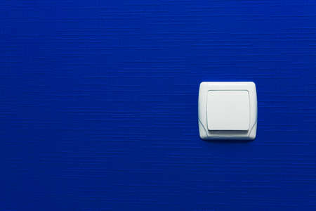 Light switch on blue wall background. Interior design. Minimal styleの写真素材