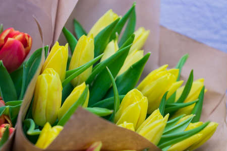 Blooming spring bouquet of yellow tulip flowers in a craft paper. Gift for womans day or birthday