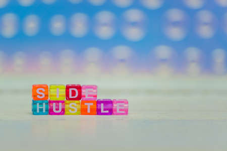 Side hustle phrase made of cube beads of different colors. Concept of additional incomeの写真素材