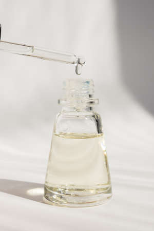 Dropper glass Bottle Mock-Up. Cosmetic pipette serum on white background with shdows and hard light.