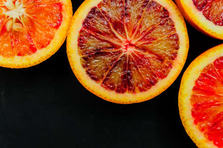 Close up of fresh juicy halves of re Sicilian oranges with copy space