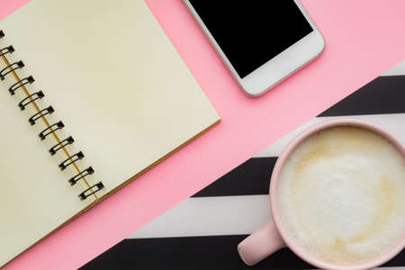 Modern white office desk table with smartphone and cup of coffee. Blank notebook page for input the text. Top view, flat layの写真素材