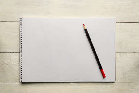 red pencil on blank white album paper. Top view. school and office supplies. Copy space