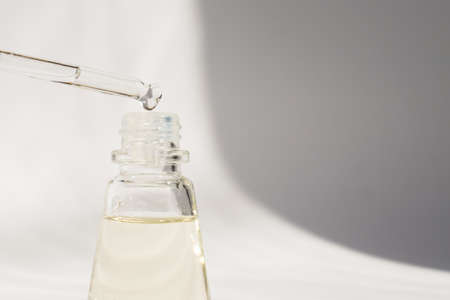 Dropper glass Bottle Mock-Up. Cosmetic pipette serum on white background with shdows and hard light.の写真素材