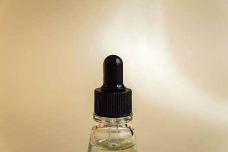 close up of clear glass serum bottle with essential on pastel beige backgroundの写真素材