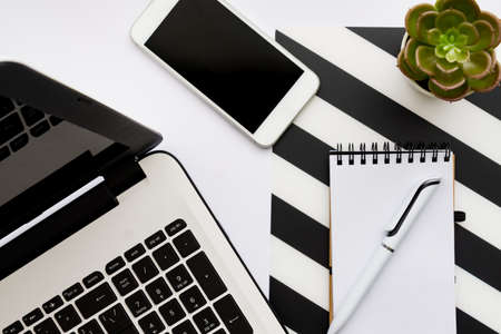 Home office workspace mockup with laptop, potted succulent, notebook and accessories. Flat lay, top view.の写真素材
