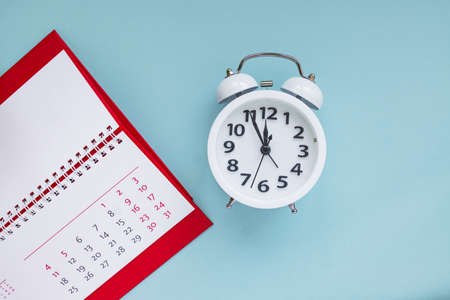 close up of calendar and alarm clock on the blue background, planning for business meeting or travel planning concept.の写真素材