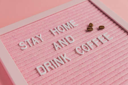 Quote stay home amd drink coffee on pink background. Work at home during coronavirus pandemia....