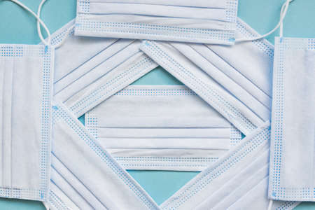 medical masks on blue background with copy space. hygienic quarantine concept. Flat lay, top view.
