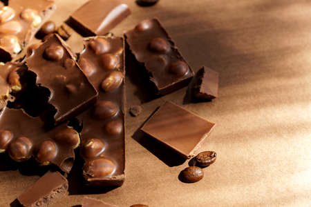 Close up of milk chocolate with hazel nuts on brown background. Copy spcace for text.の写真素材