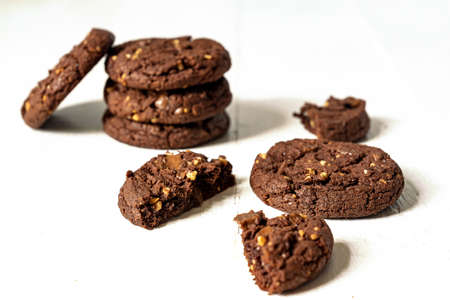 Stuck of Homemade american chocolate cookies with nuts on white wooden background. Fresh pastry