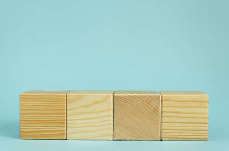 Construction of wooden cubes on blue background with copy space. Mockup composition for design.の写真素材