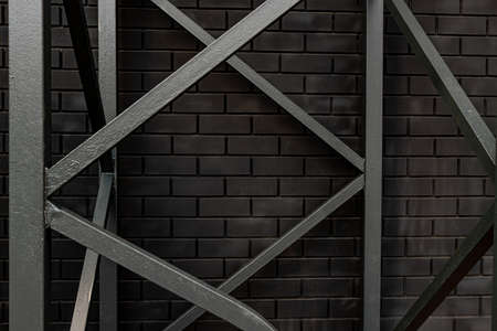black brick wall and metall concstruction - woundation of outdoors ledder. Abstract industrial backgroundの写真素材