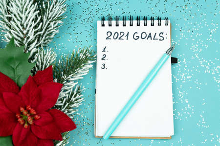 Notepad with handwrittrn 2021 goals for new year. Resolutions list