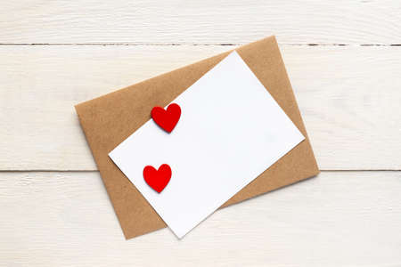 greeting card template with craft paper envelope and bright red hearts. card text design for social...