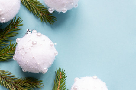 Christmas minimal concept - Christmas composition with fir branches and white baubles. Horizontal frame, flat lay, view from above. Pastel blue background with copy space.の写真素材