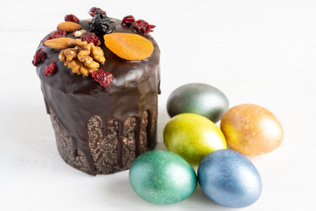 Easter cake and colored eggs on white background. Holiday food and easter concept.