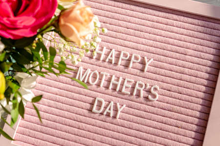 Happy Mother's day background with pink letter board and spring flowersの写真素材