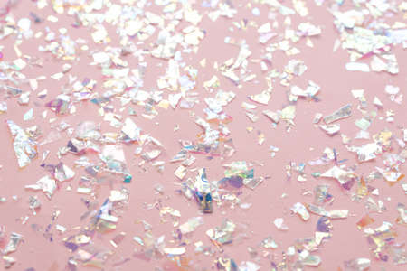 neon pearl foil confetti on light pink background. Festive, party or holiday glowing backdrop. Flat lay, top viewの写真素材
